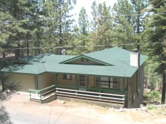 Summer view of house showing street-level entry to garage and main floor